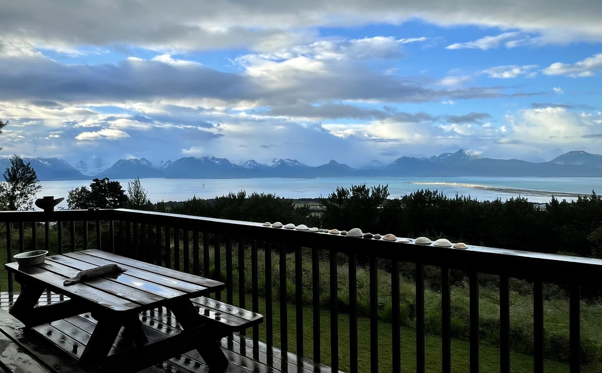 View from the rose room balcony showing the yard and a bright pink sunset over snow-capped mountain peaks